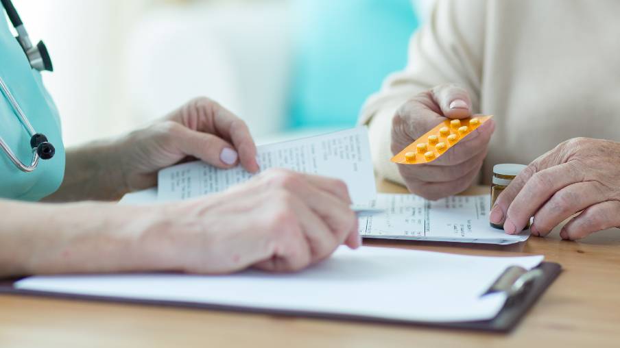 enfermera con paciente en consulta revisando medicación